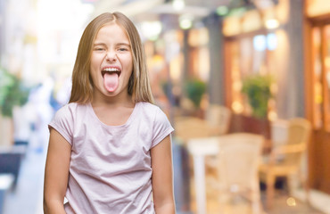 Young beautiful girl over isolated background sticking tongue out happy with funny expression. Emotion concept. © Krakenimages.com