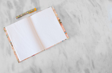Diary and Pen sitting on a marble table