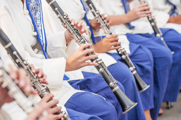 Teen Band in white-blue uniform performing in music festival.
