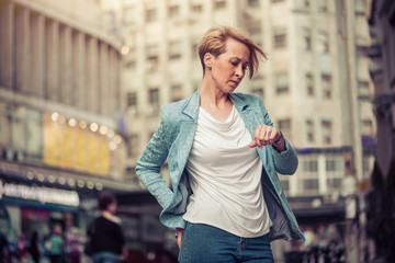 Fototapeta premium Stylish mid-age woman waiting for someone in the street