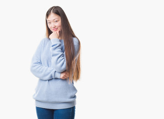 Young Chinese woman over isolated background looking confident at the camera with smile with crossed arms and hand raised on chin. Thinking positive.