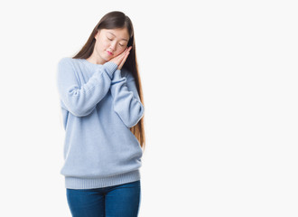 Fototapeta premium Young Chinese woman over isolated background sleeping tired dreaming and posing with hands together while smiling with closed eyes.