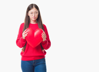 Young Chinese woman wearing graduate uniform red heart with a confident expression on smart face thinking serious