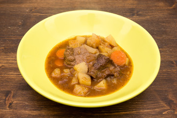 Stew of meat and vegetables on a wooden table