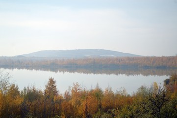 Morning mood in autumn on the water with fog, lake with waves and trees on the 