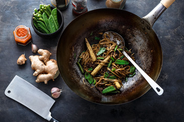 Noodles with beef preparation process, dark background