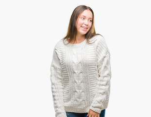 Young beautiful caucasian woman wearing winter sweater over isolated background looking away to side with smile on face, natural expression. Laughing confident.