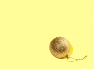 Yellow ball Christmas toy on a yellow background