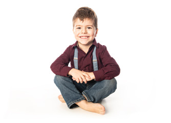 A four year old boy posing over white studio background