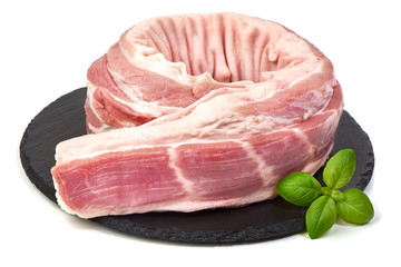 Fresh Raw Pork Tenderloin on a slate shale plate with basil leaves, isolated on a white background. Close-up.