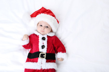 Little boy in christmas costume lying on bed