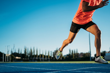 Young athlete man starting to run in a start position in a race. Start stride
