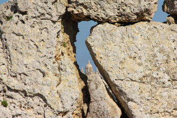 View of big church dome through hole in giant ancient stones Ggantija Temples