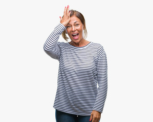 Middle age senior hispanic woman over isolated background surprised with hand on head for mistake,...