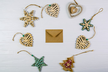 Christmas composition. Envelopes with christmas toys on wooden white background. Flat lay, top view.