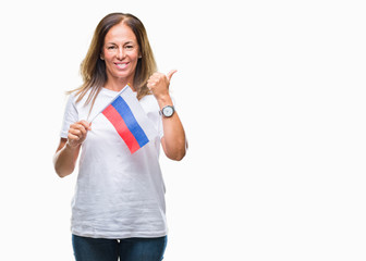 Obraz premium Middle age hispanic woman holding flag of Russia over isolated background pointing and showing with thumb up to the side with happy face smiling