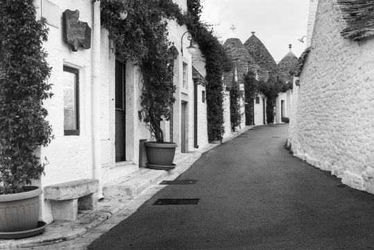 monochrome photo of street and old white houses in Alberobello in Puglia in Italy