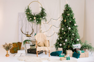 Cozy house for the new year. A beautiful wicker chair stands near decorated Christmas tree. Gift...