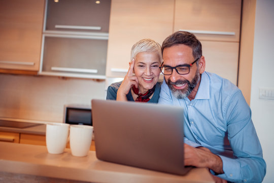Mature couple using laptop - Powered by Adobe