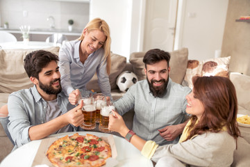Group of friends enjoying pizza and beer