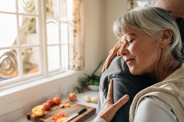Close up of an elderly woman hugging her husband