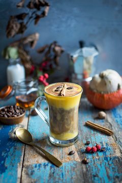 Pumpkin latte garnished with coffee bean and cinnamon stick