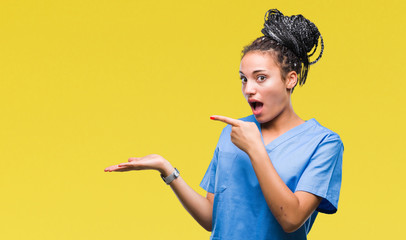 Young braided hair african american girl professional nurse over isolated background amazed and...