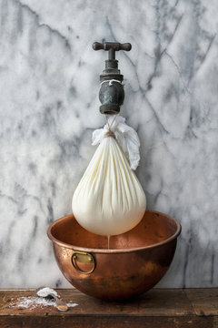 Greek yogurt draining over copper bowl