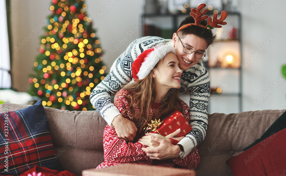 Wall mural happy couple opening presents on Christmas morning.