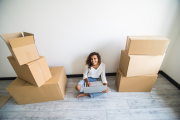 Above view of smiling woman using computer of new house and smiling