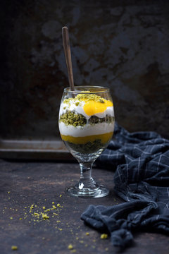 Dessert in glass made with matcha cake, mango puree and soya yoghurt