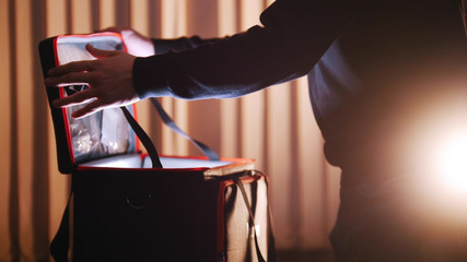 A man opening case with light in it and looking inside