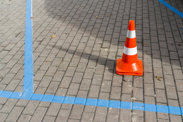 car markings on a stone tile with a car cone