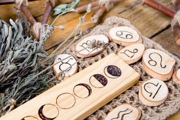 Moon Phases and astrological symbols with herb bundles