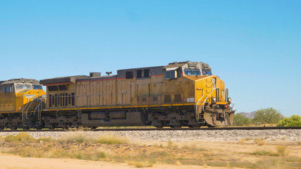 CLOSE UP: Locomotive moving long freight container train along railroad tracks