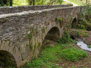 Arches of an old stone bridge called Ponte Aspera - Sarria, Galicia, Spain