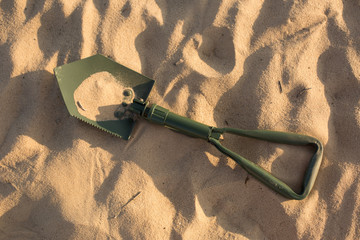 marching shovel. shovel in the sand. green shovel. sand. desert. army shovel © Svetlana