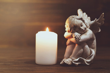 Angel and white burning candle