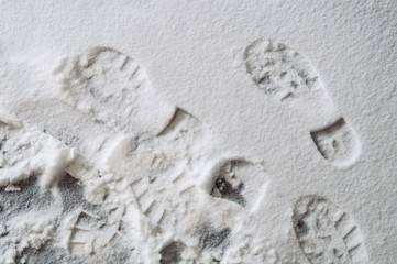 Footprints on fresh white snow, top view. Winter background.