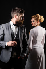 Elegant couple with red wine. Romantic couple spending time together. Handsome man with glass wine. Beautiful woman in white dress. Couple drinking glass wine. Girl flirting with man with glass wine.