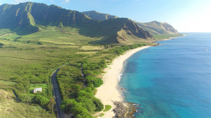 Fototapeta na wymiar AERIAL: Red convertible driving on beautiful coastal road in volcanic island