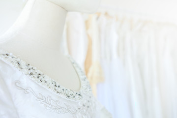 Obraz na płótnie Canvas Closeup beautiful bridal dress on a hangers model in wedding dress store