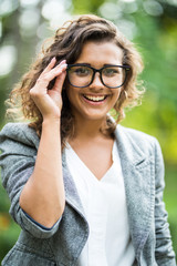 Close up portait of business woman in eyesglasses walking outdoor.