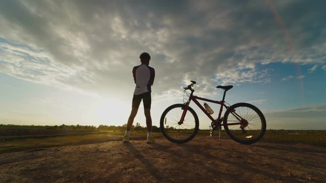 man with bicycle with sunset background,time lapse