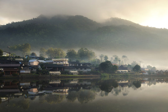 Beautiful scenery during sunrise with the mist and water reflection of the Chinese village at the Lee wine ruk thai lake, Mae Hong Son in Thailand is a very popular for photographers and tourists