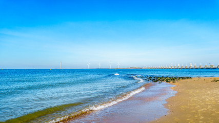The wide sandy beach at Banjaardstrand along the Oosterschelde inlet at the Schouwen-Duiveland peninsula in Zeeand Province in the Netherlands. The Storm Surge Barrier in the background