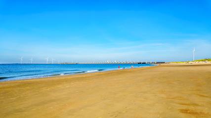 The wide and clean sandy beach at Banjaardstrand along the Oosterschelde inlet at the Schouwen-Duiveland peninsula in Zeeand Province in the Netherlands. The Storm Surge Barrier in the background