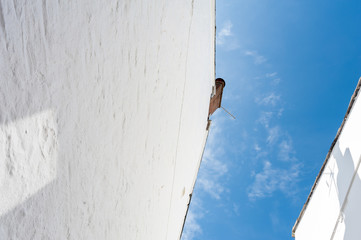 View from below of the sides of two whitewashed buildings in Cornwall, UK.