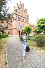 Pretty young american college student smiling happy, holding a backpack are a walk to class in the University.