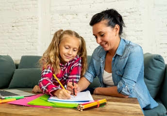 Single mum helping her daughter doing her homework with laptop at home